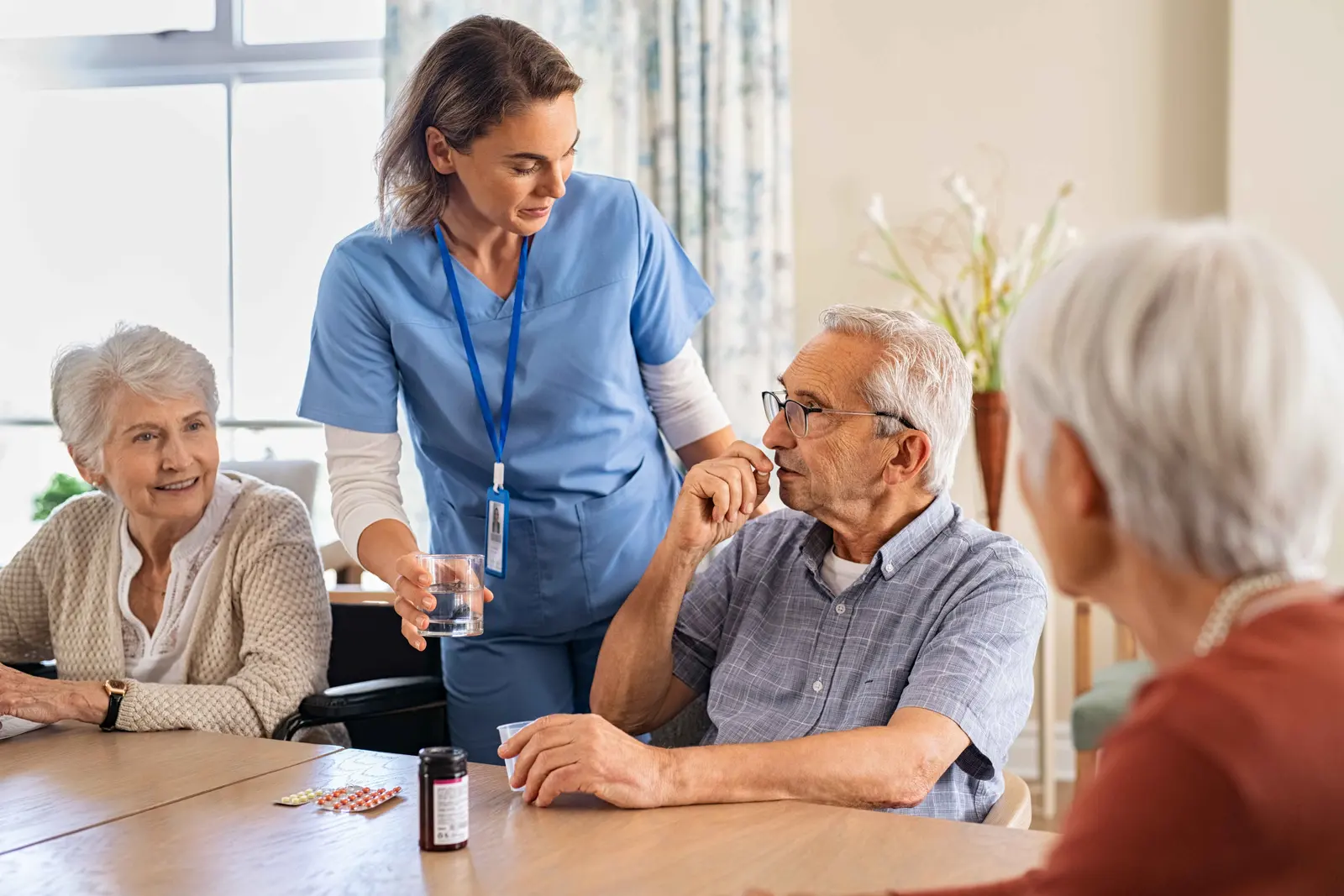 Medication being sorted and explained on a kitchen table